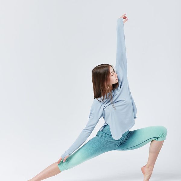Woman in a graceful yoga pose against a calm background.